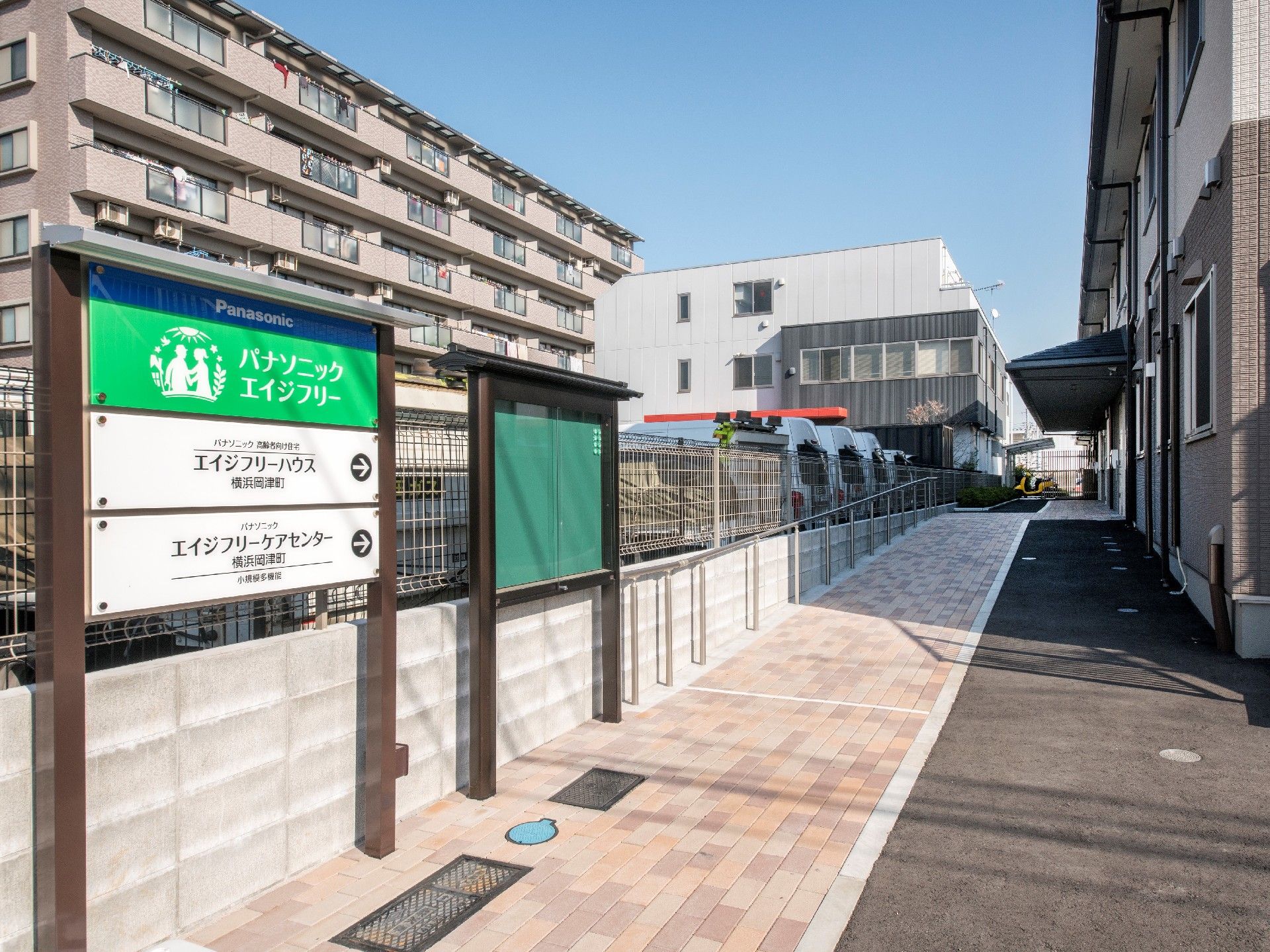 住宅地に位置し、建物の近くには看板と掲示板が立っている。