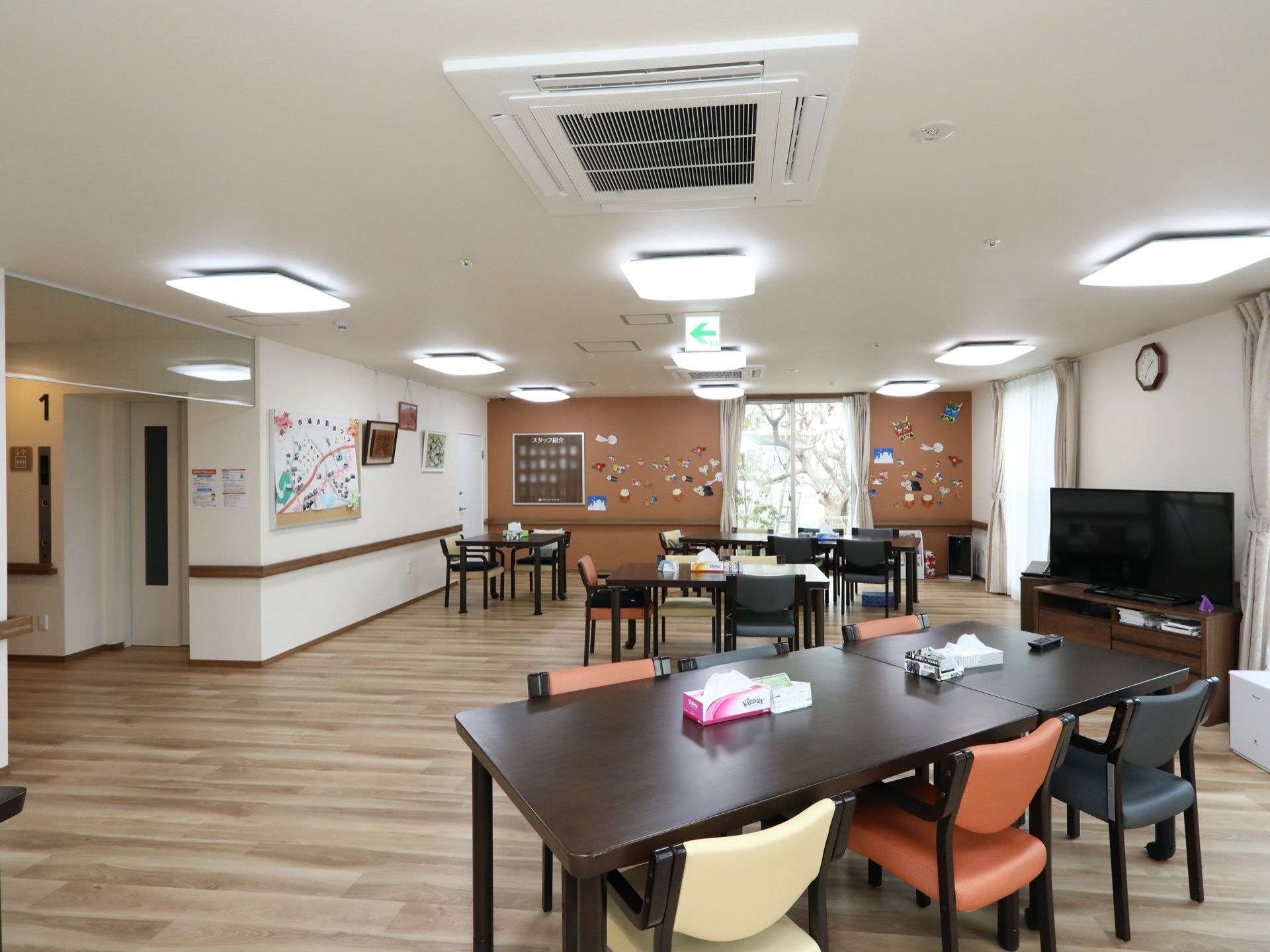 天井に大きな埋込式のエアコンが設置されており、その周りには、四角い照明器具が複数並んで取り付けてある。