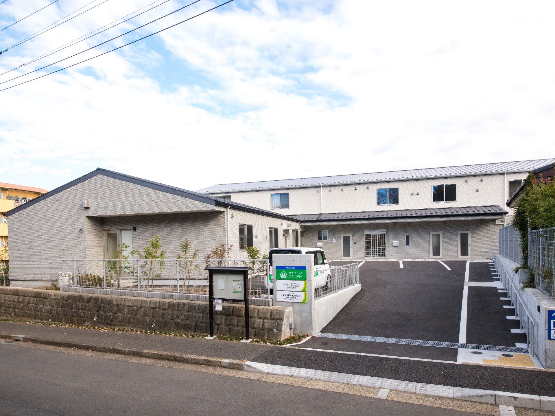 2階建ての建物と平屋建ての建物が同じ敷地内にあり、広い駐車場が付いている。