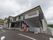 ツートンカラーの２階建ての施設である。柵がついた非常階段が設置されている。その下に、飲料の自動販売機がある。