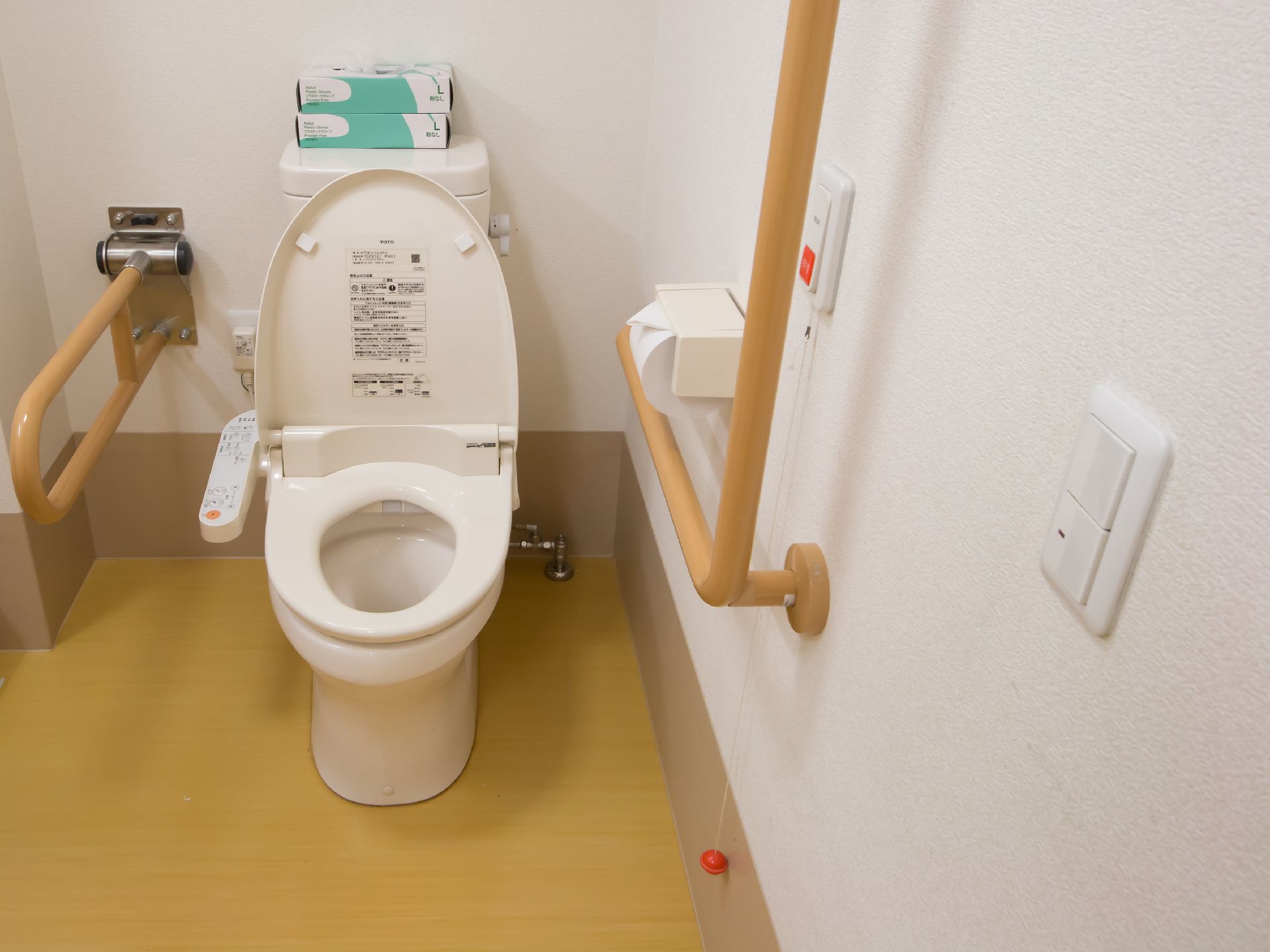緊急用ボタンが便器のすぐ横にある機能的なシステムトイレ