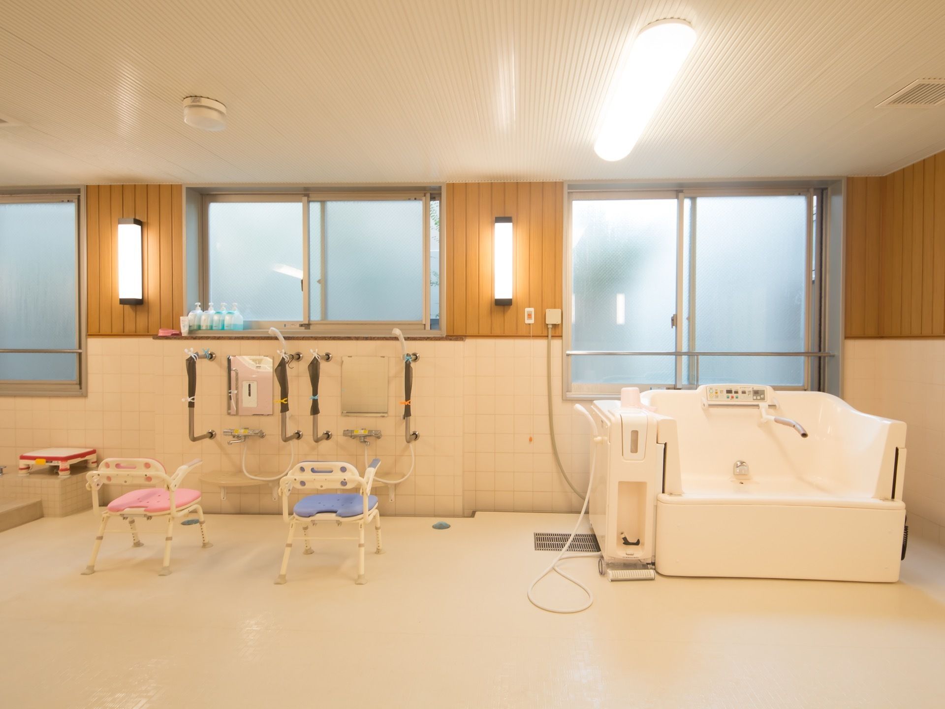 広い空間の浴室である。天井と壁には照明を設置しているため、足元が見やすく入居者様は安全に通行することができる。