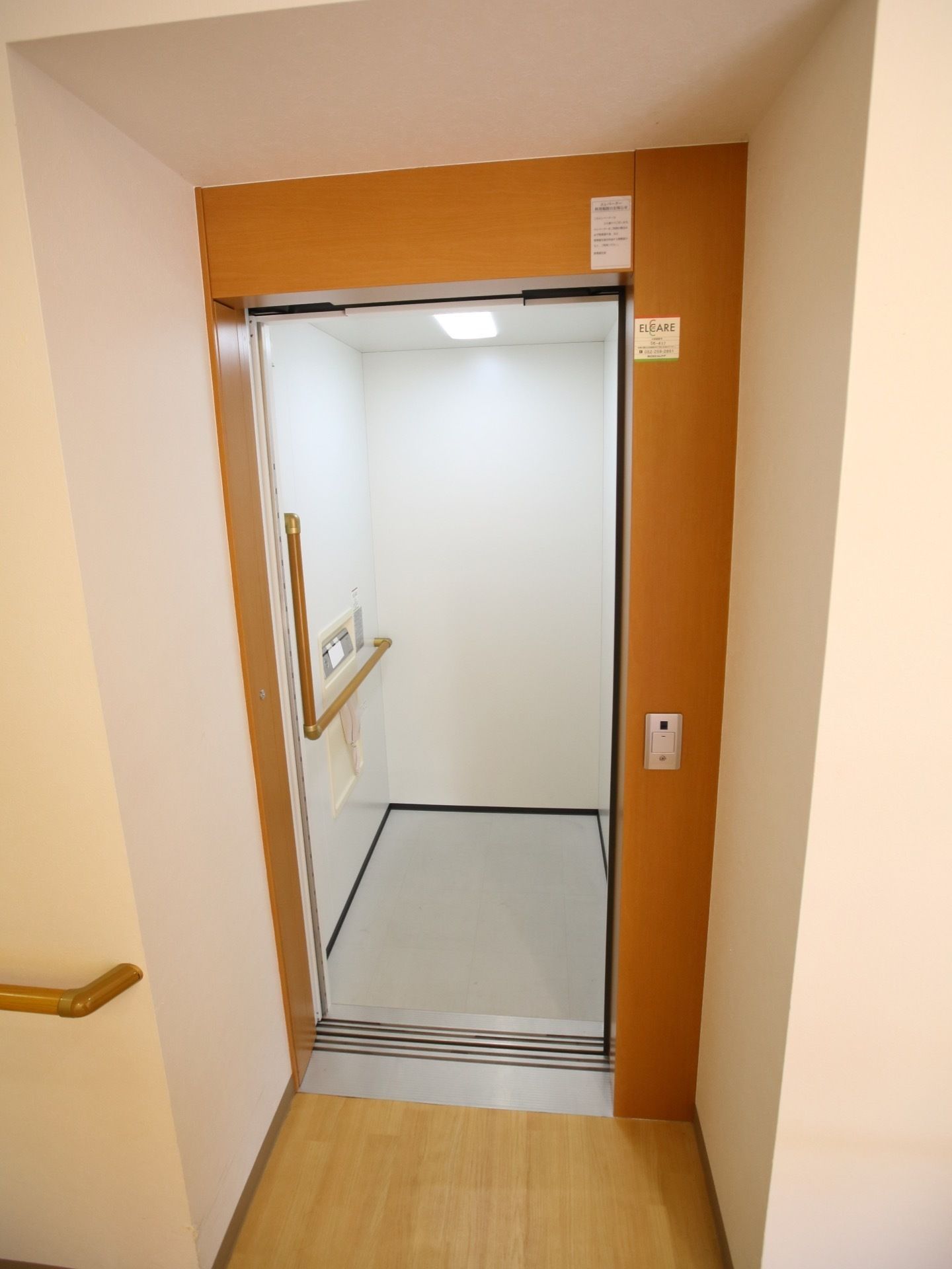 エレベーターの乗降口は、廊下から少し奥まった所にある。内部の壁にある操作パネルを取り囲むようにL字型の手すりがある。