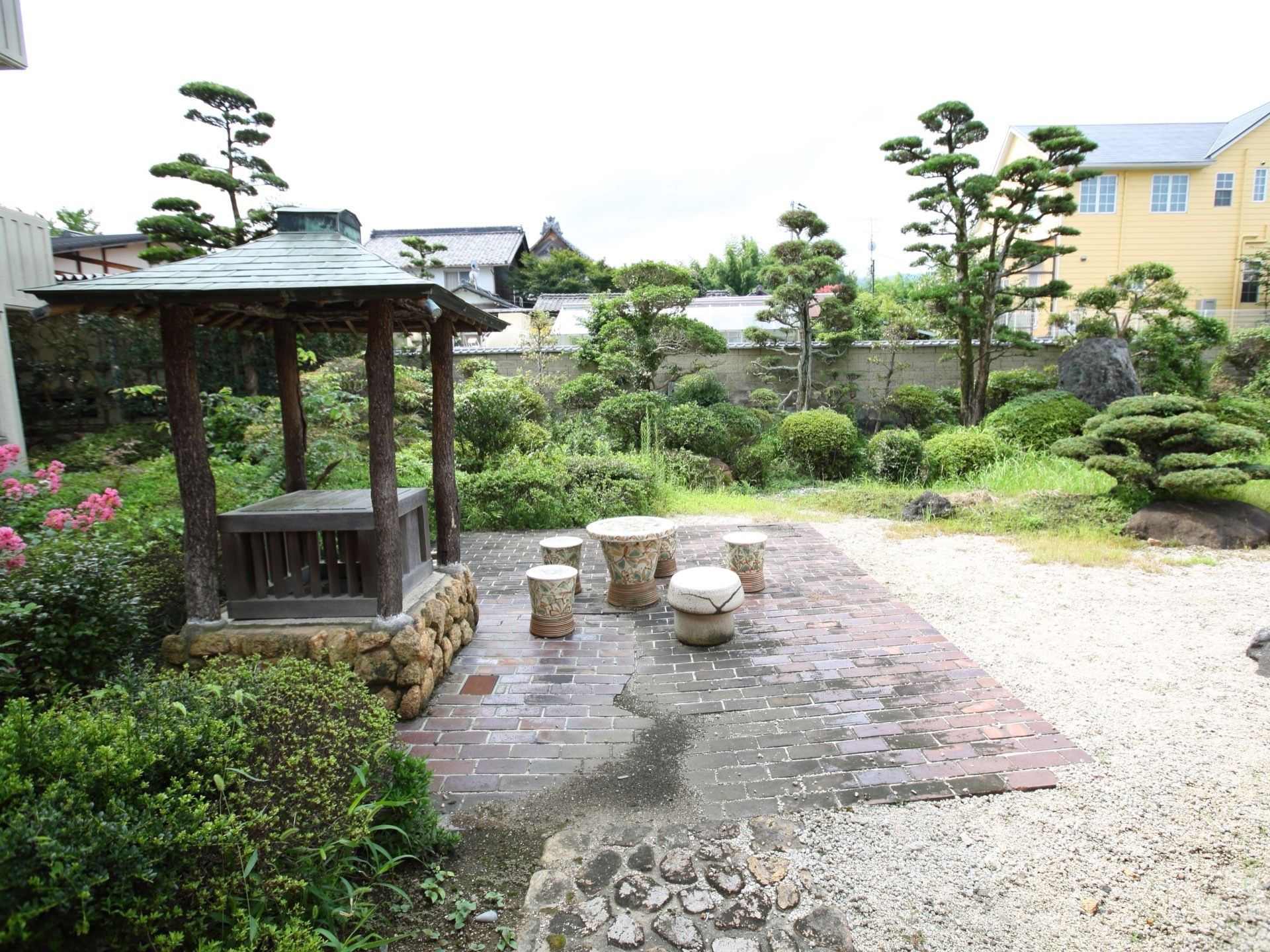 敷地内に和風庭園がある。小さな東屋があり、その近くに石製のテーブルや椅子がある。塀際に多くの木が生えている。