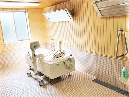 パネルヒーターが天井につけられた浴室には機械浴が置かれている。