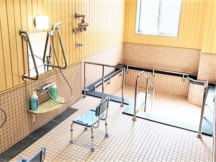 シャワーの前にはシャワーチェア。窓の近くにはお湯が張られていない大きな浴槽がある。