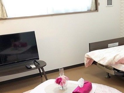 ベッドには布団がセットされ、テーブルには花が飾られ、大きなテレビもある。
