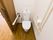 引き戸式の扉が設置されている。床はフローリング仕様。洋式のトイレを完備している。両側に手すりもある。