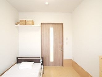 フローリングのシンプルな居室。収納やベッドが設置されている。