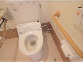 手すりと緊急コールが取り付けてある高齢者用のトイレ。施設内の設備