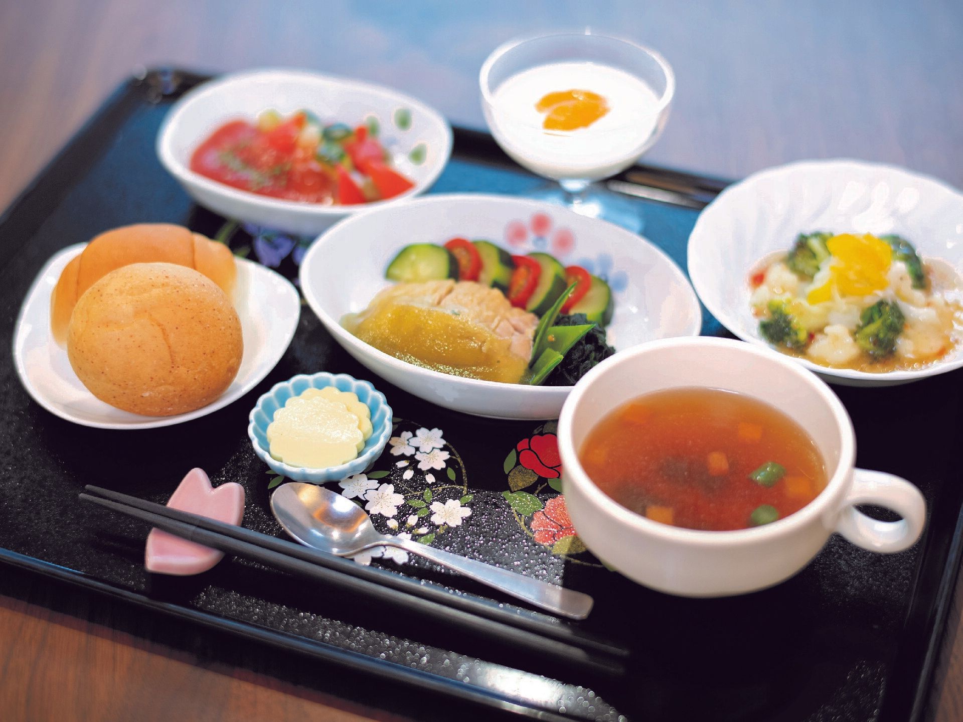 スープにパン、野菜の煮物やあえ物などがそれぞれ器に盛られ、桜の花びらの形の箸置きに箸が置かれ、スプーンも添えらえている。