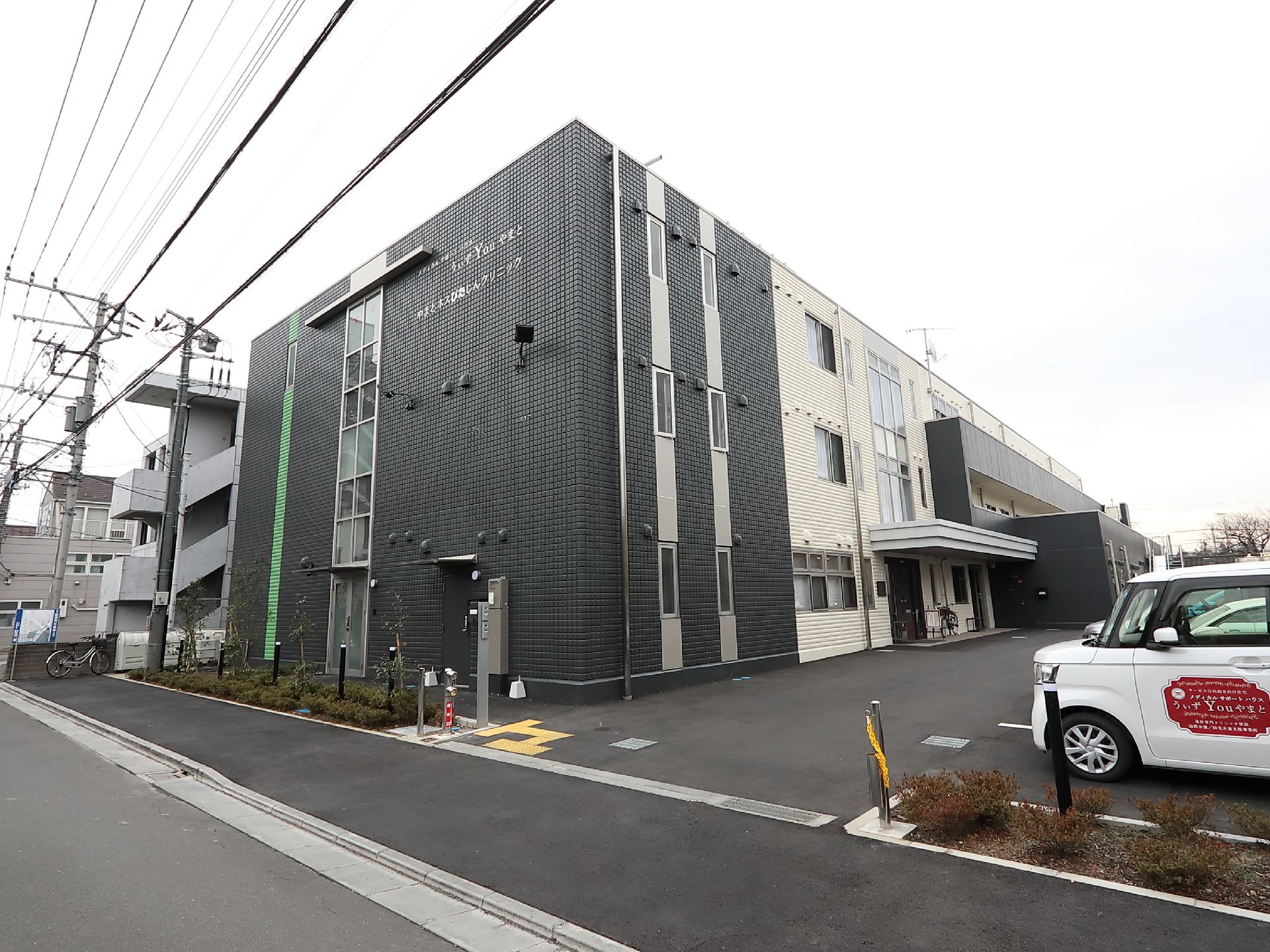 横に長い鉄骨造の建物の外観が写っている