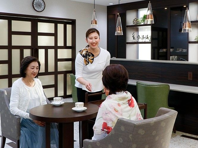 リラックススペースでくつろぐ高齢者とその家族の様子。施設内に用意されたカフェ