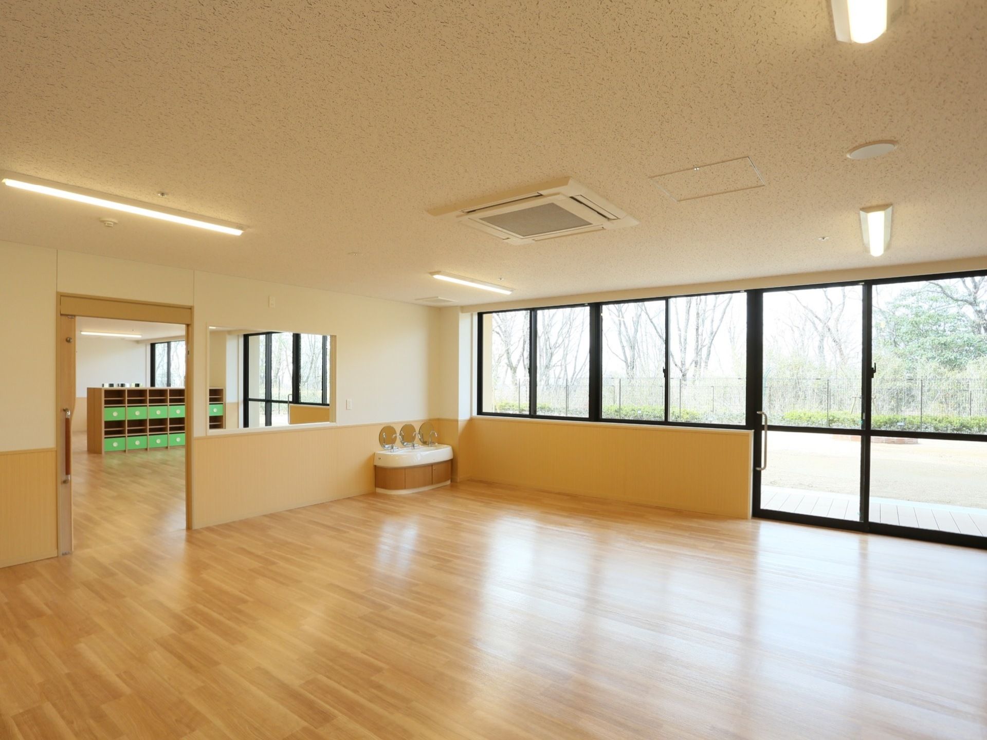 大きな窓がある広い共有スペースである。出入り口の扉はスライド式になっており、大きな取っ手があるので、少ない力で開閉することができる。