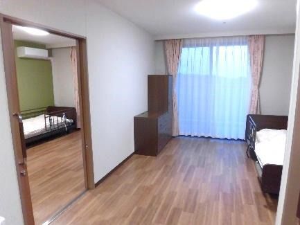 引き戸で仕切られた二人部屋。それぞれの部屋にベッドや家具が置かれている。