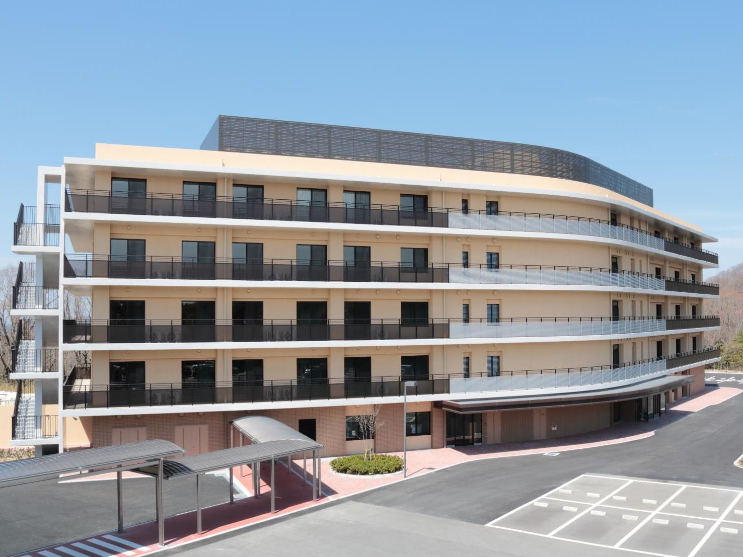 各フロアにベランダが付いた５階建ての建物。災害に備えて屋外に階段もある。