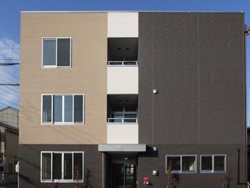カラーリングが印象的な鉄骨造の建物の写真。直線的なデザインの高齢者向け施設