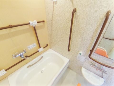 シャワーチェアや手すりが設置され、安全に配慮された浴室には一人用の浴槽がある。