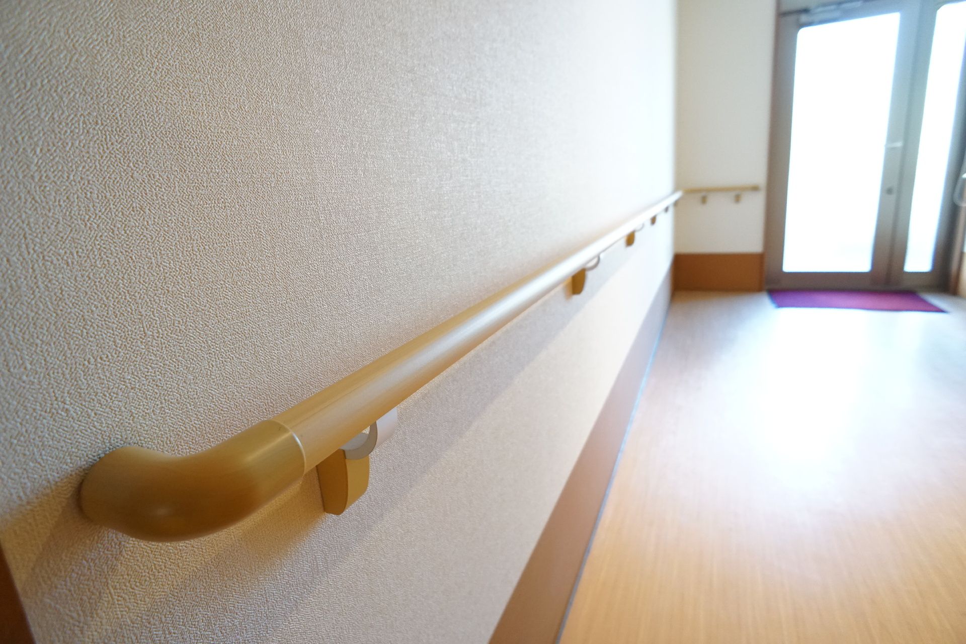 白い壁に設置されたブラウンの手すり