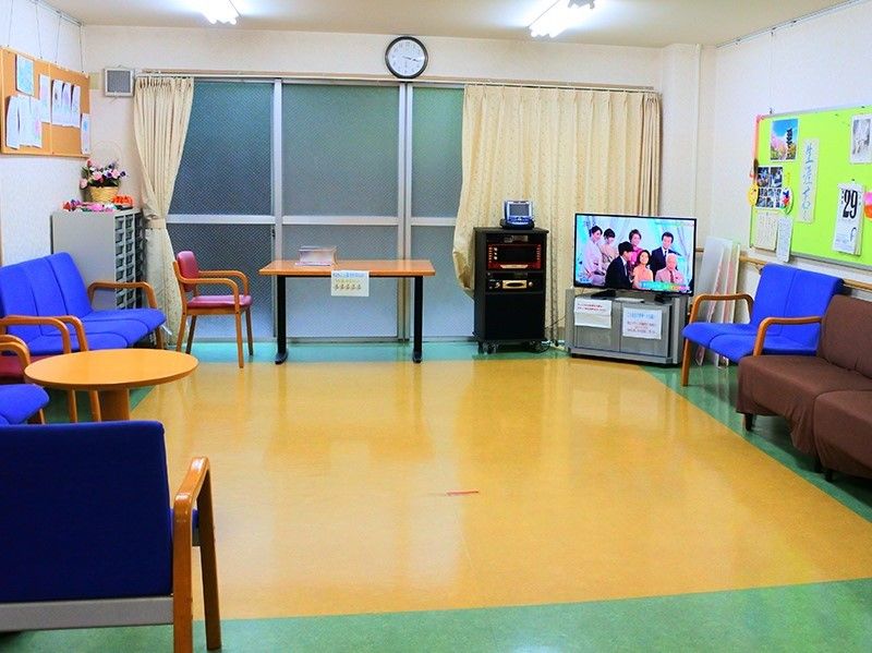 広めのリビングにいすとソファ、テレビなどを置いてある様子。共有スペースの写真