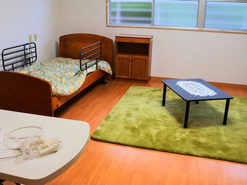 居室の様子を写した写真。ベッドやタンス、テーブルが写っている写真