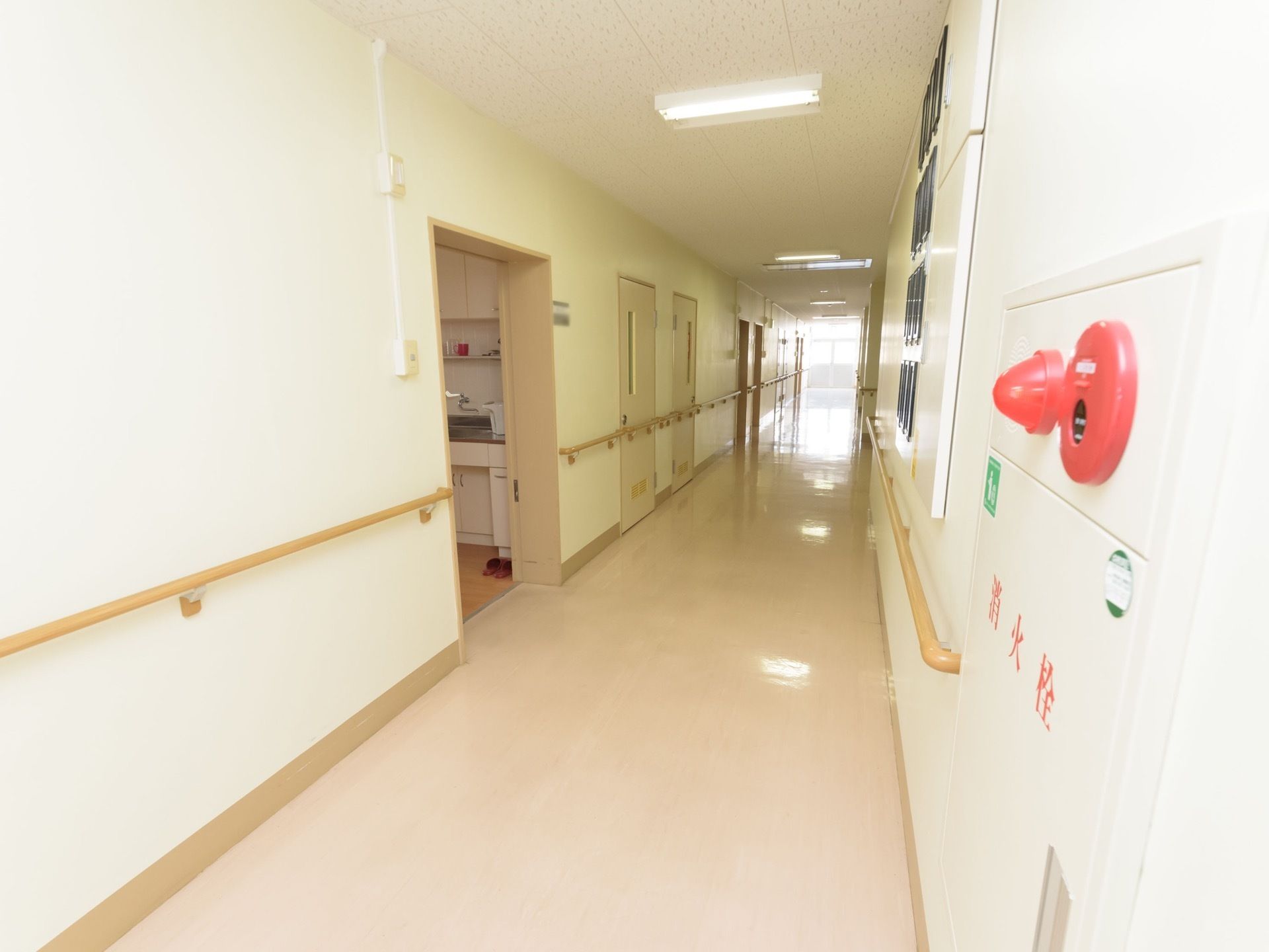 白を基調としたさわやかさを感じる廊下である。両側の壁には手すりを完備し、災害時に備えた消火栓を設置している。