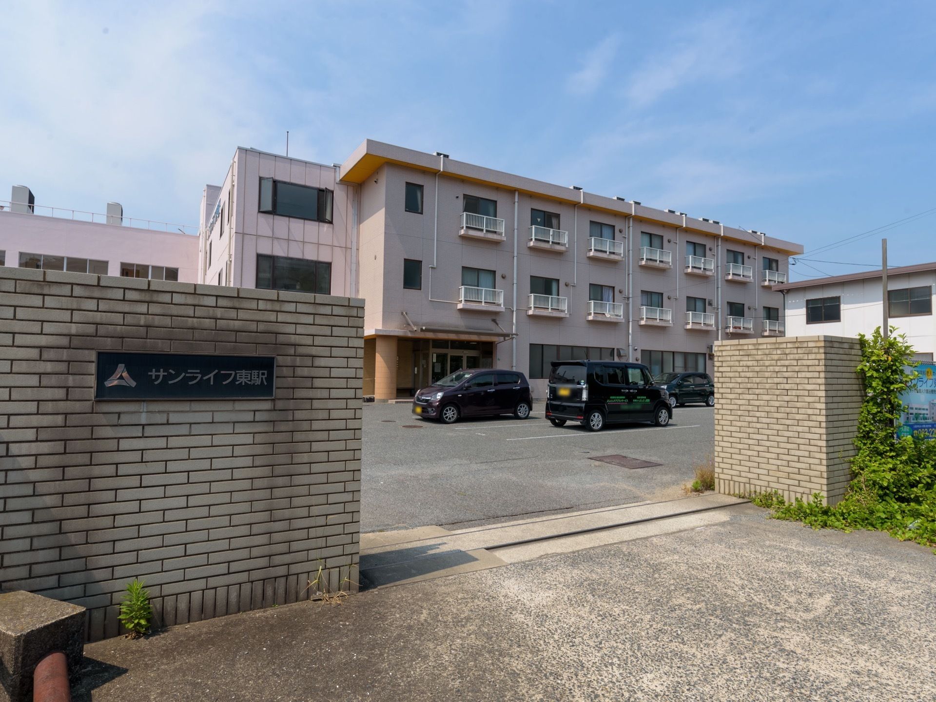 学校を思わせるような３階建ての大規模な建物である。ブロック塀があり、莫大に広い敷地内には駐車スペースがある。