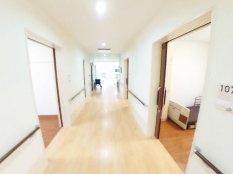 廊下には手すりが付き、両サイドに居室が並んでいる。天井が高く白を基調とした開放感がある造り。