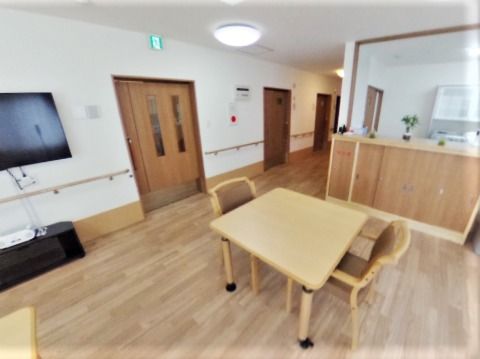 木目調の家具やフロアと白い壁が穏やかな雰囲気を演出。対面式のキッチンからはリビングダイニングを見渡すことができる。