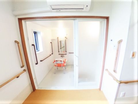脱衣所は広く、浴室に続く大きな引き戸が付いている。手すりは縦横に多くついている。