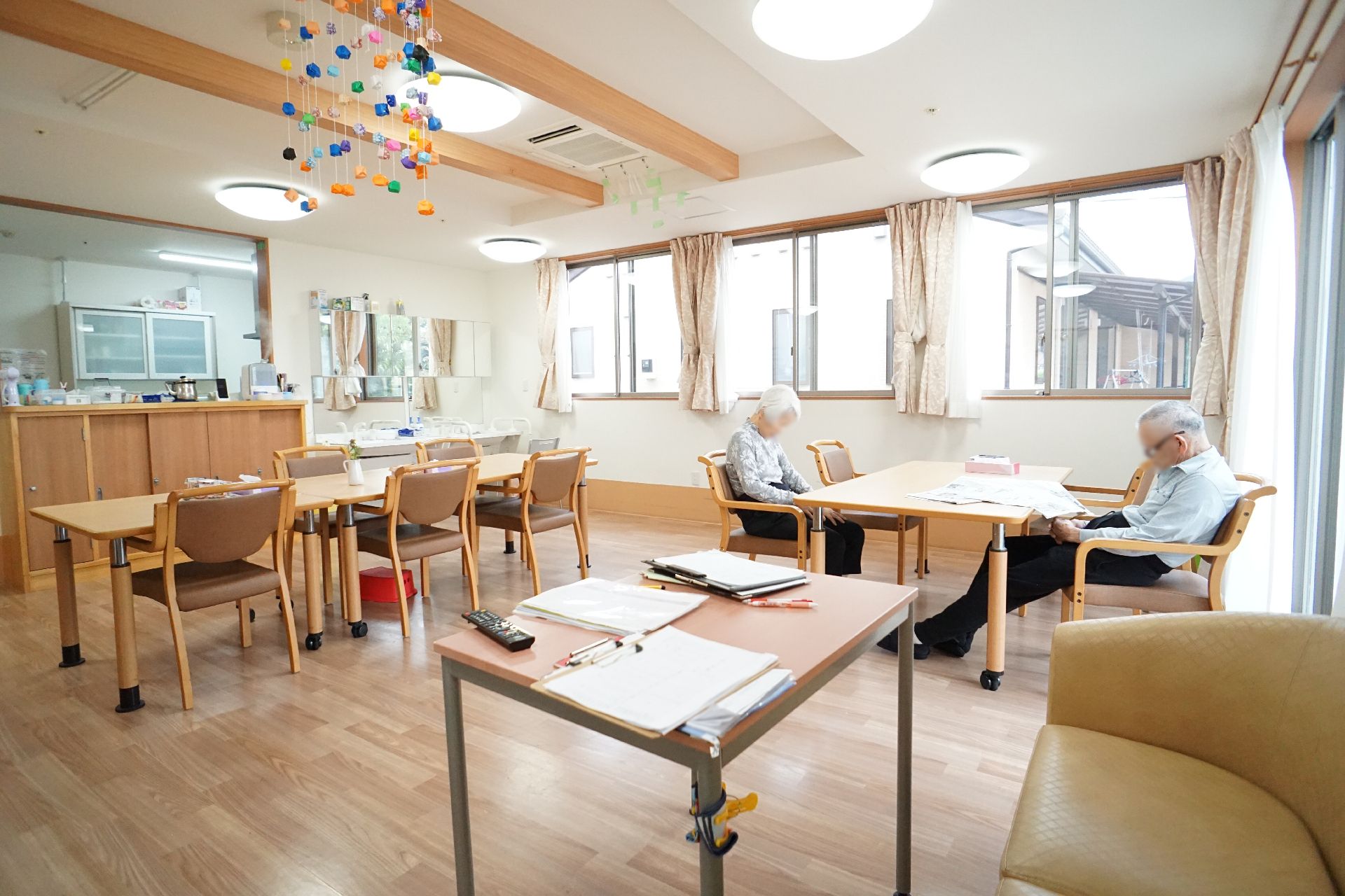 入居者が新聞を読んでいる様子の共有スペース