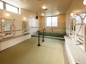 手すりが付いた大浴場の写真。シャワースペースがあるのが分かる写真