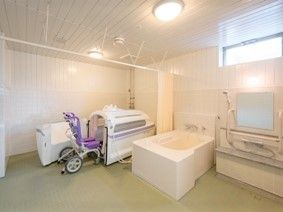 介護仕様の設備の写真。車いすのような設備で入れる介護浴槽と個浴の写真