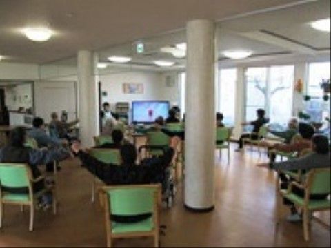 テレビ画面を見ながら体操をしている入居者たち