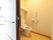 居室のトイレは引き戸で大きく開閉する。便座には蓋がない。壁に手すり、緊急用のボタンが取りつけられている。