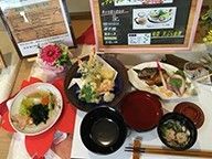桜の花の形をしたランチョンマットの上に並べられたごちそう。メニュー表も飾られている。