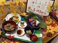 紅葉の飾りがされたテーブルの上には秋らしい食材を使用した豪華な料理が並んでいる。