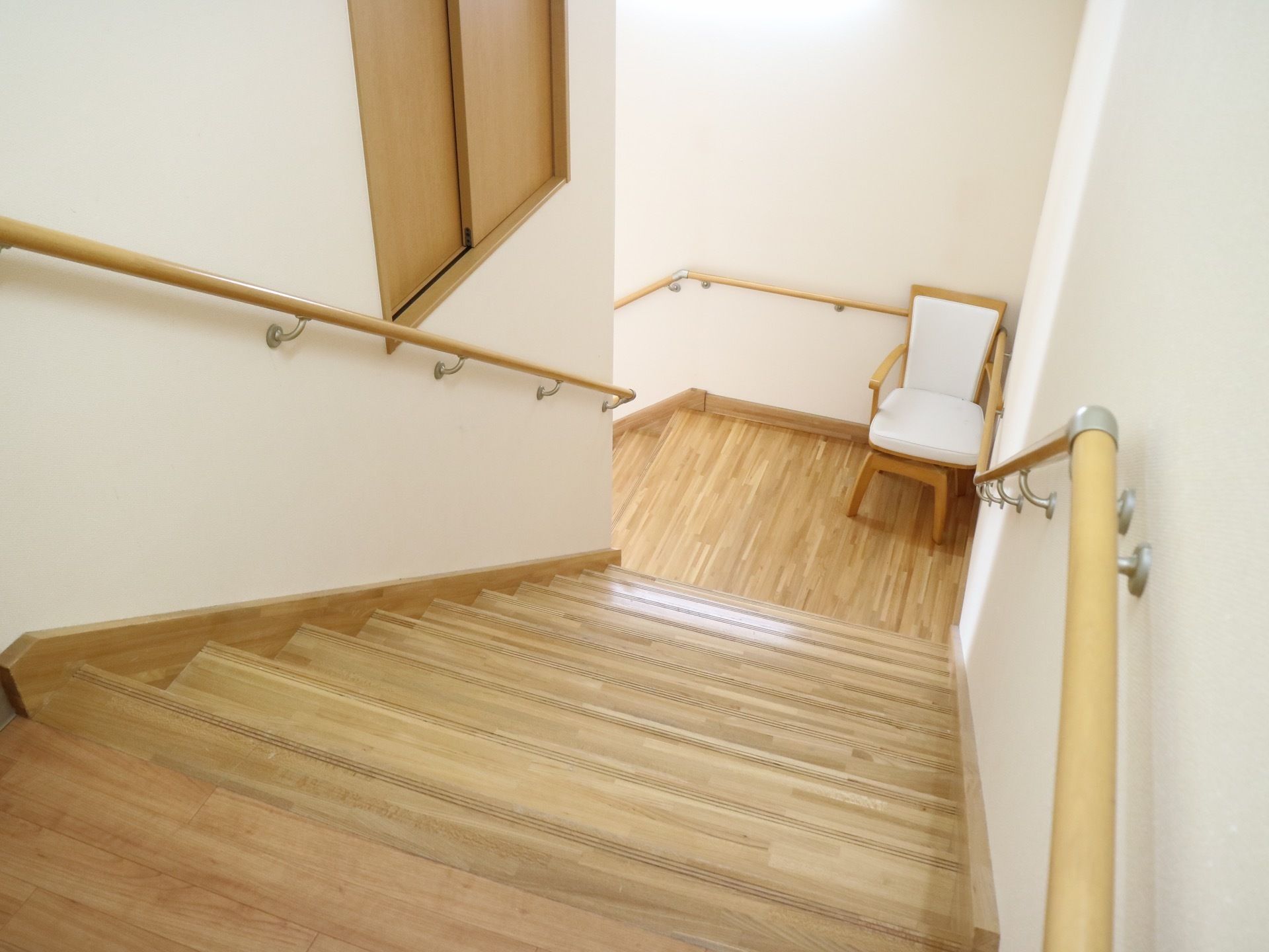 階段の両側の壁には手すりが設置されており、つかまりながら上り下りすることができる。途中の踊り場部分には椅子が置かれている。