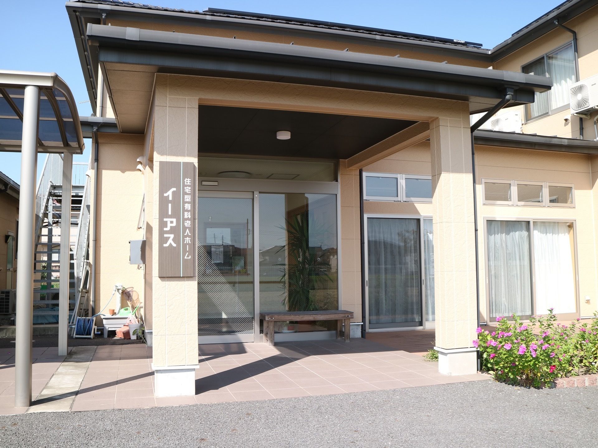 屋根があり大きなガラスドアの付いた玄関