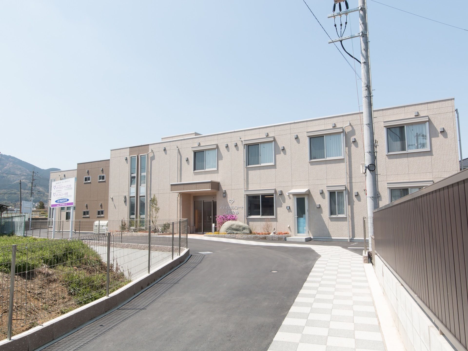建物の手前にはなだらかな坂道が続いている。横幅があるため、大型の車でも難なく通ることができる。道は整備されており、がたつきにくい。