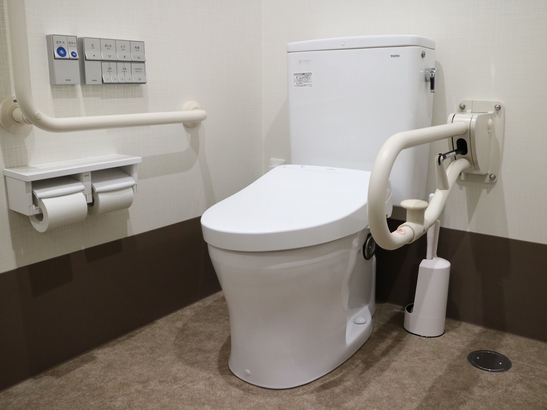 清潔感のあるトイレには、温水洗浄便座器が完備されている。壁には、L字型手すりや可動式手すりがある。