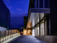 03夕暮れ時になりライトアップされた建物のエントランス部分。明かりが窓から漏れている様子。