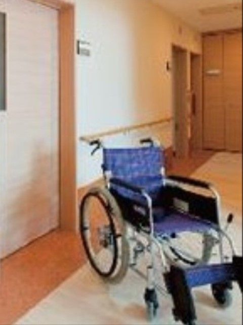 施設館内の居室前の廊下に置かれている青い座面の車椅子
