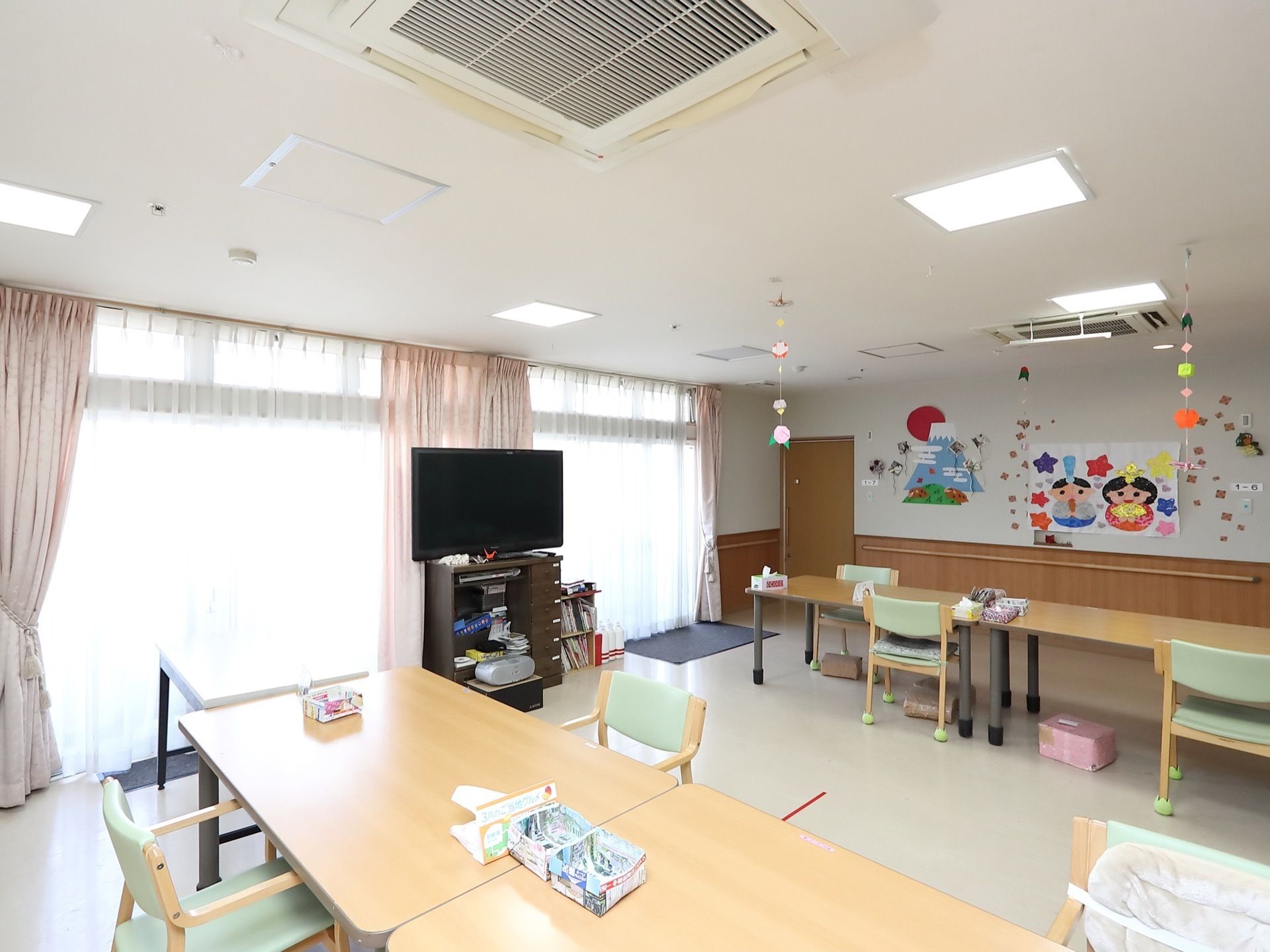 白色をベースとした広い共有スペースである。空調完備でテーブルや椅子、テレビなどが置かれている。壁には飾りつけがされている。