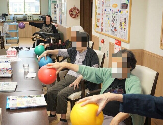 かぼちゃきんとんを作っている高齢女性と隣で見守る高齢女性