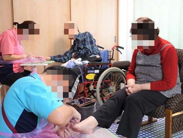 建物の前で、赤い傘をかぶった女性たちが太鼓をもって踊っている。