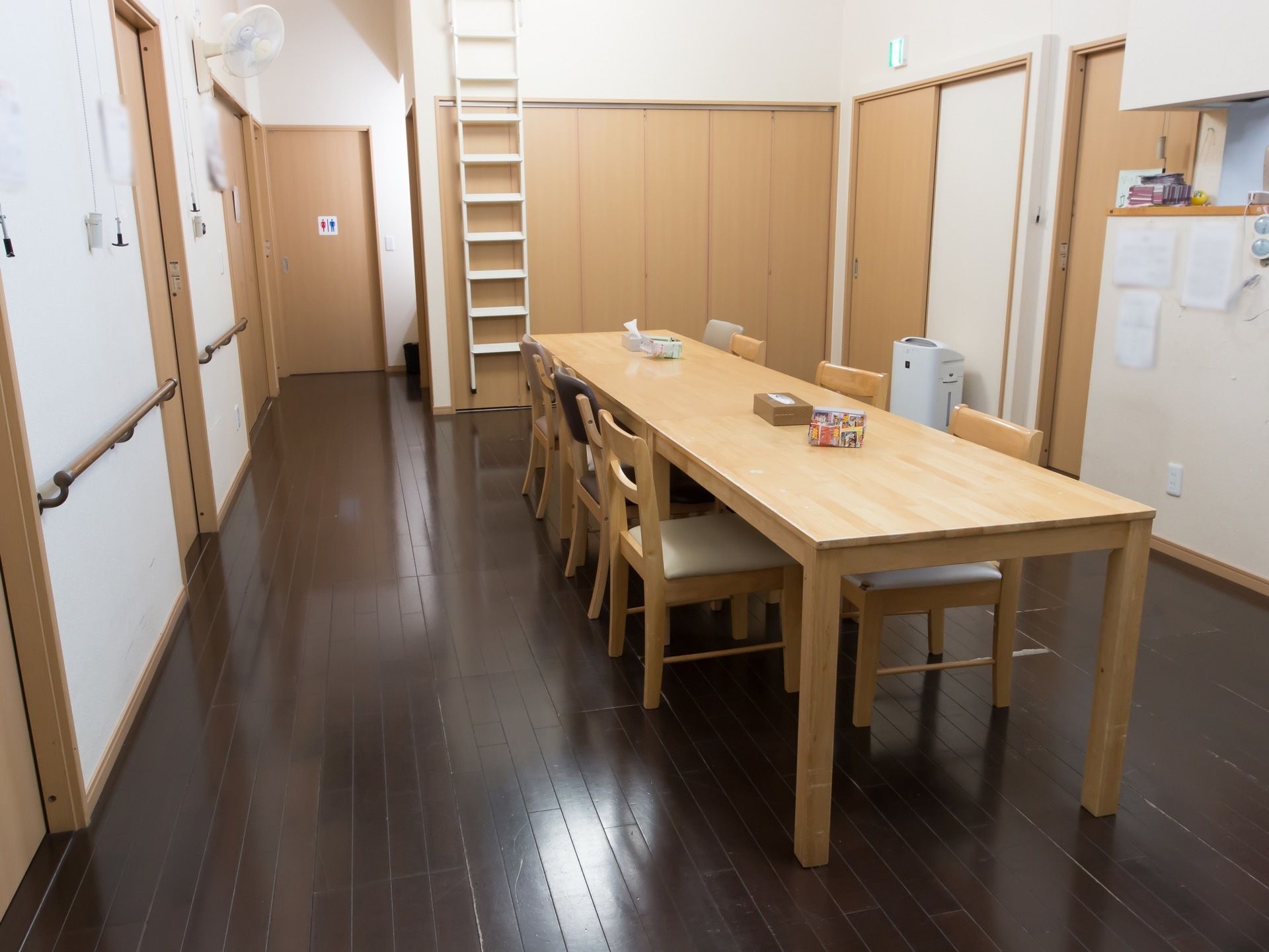 食堂の横は通路となっていて壁に手すりが設置されている。突き当たりにはトイレのマークが表示されたドアがある。