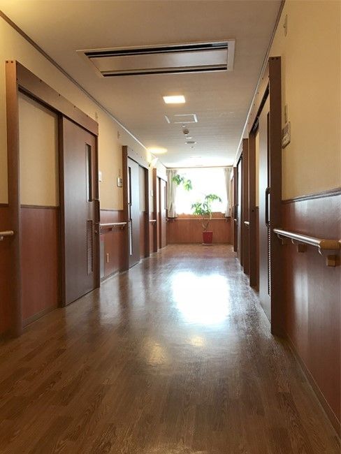 木の香りがするような木材をふんだんに使用した館内。廊下は幅が広く、大きな引き戸がそれぞれの居室についている。