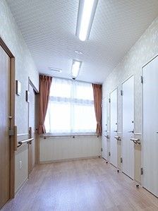 廊下の奥に窓が付いている様子。両側に個室が並んでいるのが分かる