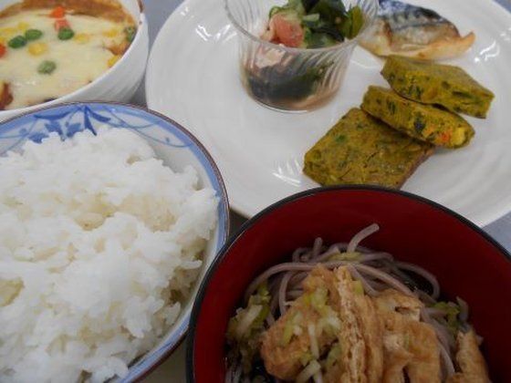 白いご飯にあげが乗ったそば、おかずが少量ずつ盛られた白いプレートに、チーズ焼きが並んでいる。